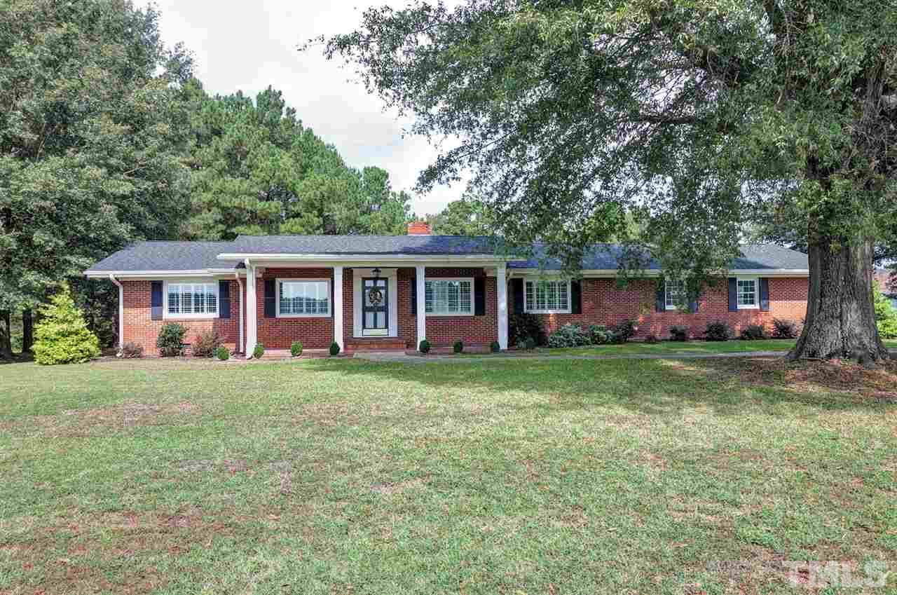 90 Johnson Town Road Zebulon, NC 27597 - Photo 1 of 18 a front view of a house with a garden