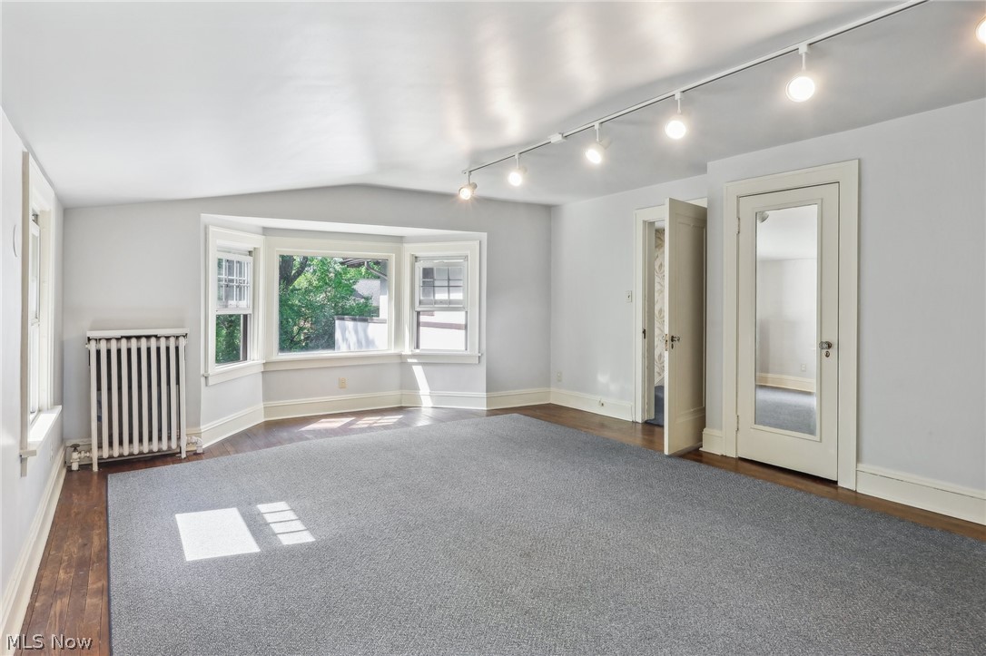 2329 Stillman Road Cleveland, OH 44118 - Photo 27 of 49 Unfurnished bedroom featuring dark hardwood / wood-style flooring, radiator heating unit, vaulted ceiling, and rail lighting