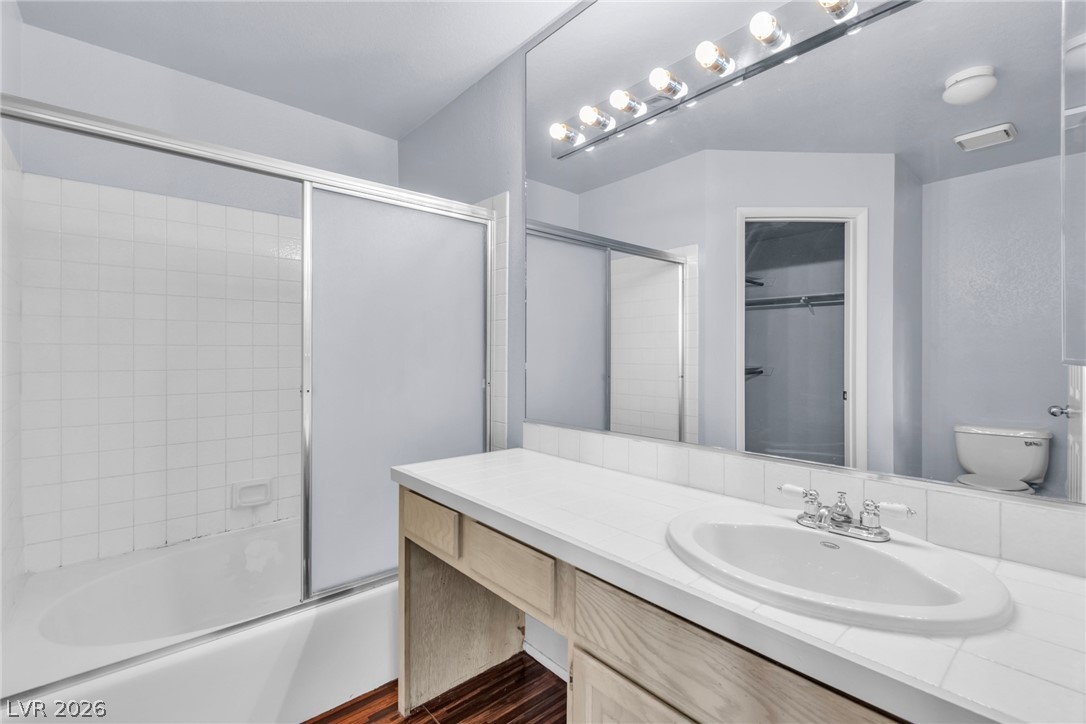 6250 West Flamingo Road, Unit 98 Las Vegas, NV 89103 - Photo 17 of 40 Bathroom with combined bath / shower with glass door, toilet, vanity, wood finished floors, and visible vents