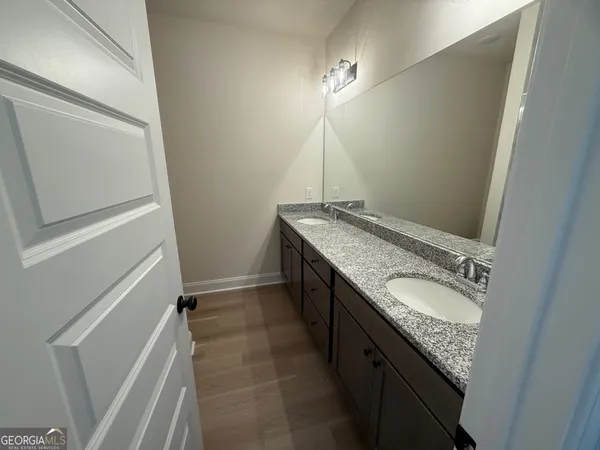 a bathroom with a granite countertop sink and a mirror
