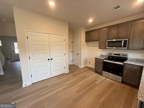 a kitchen with granite countertop white cabinets and stainless steel appliances