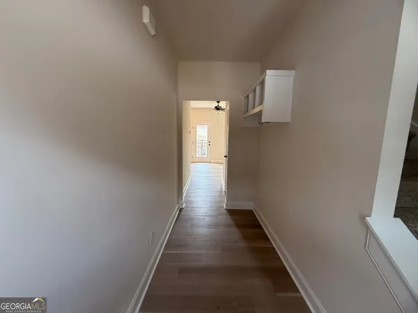 a view of a hallway with wooden floor