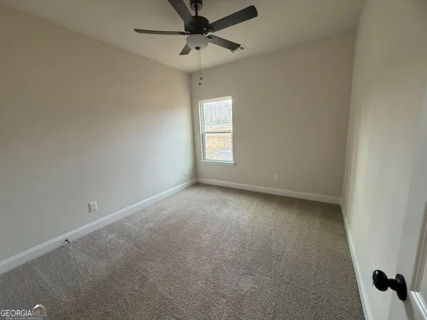 an empty room with a window and a fan