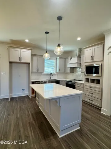 a large kitchen with kitchen island a sink stainless steel appliances and cabinets