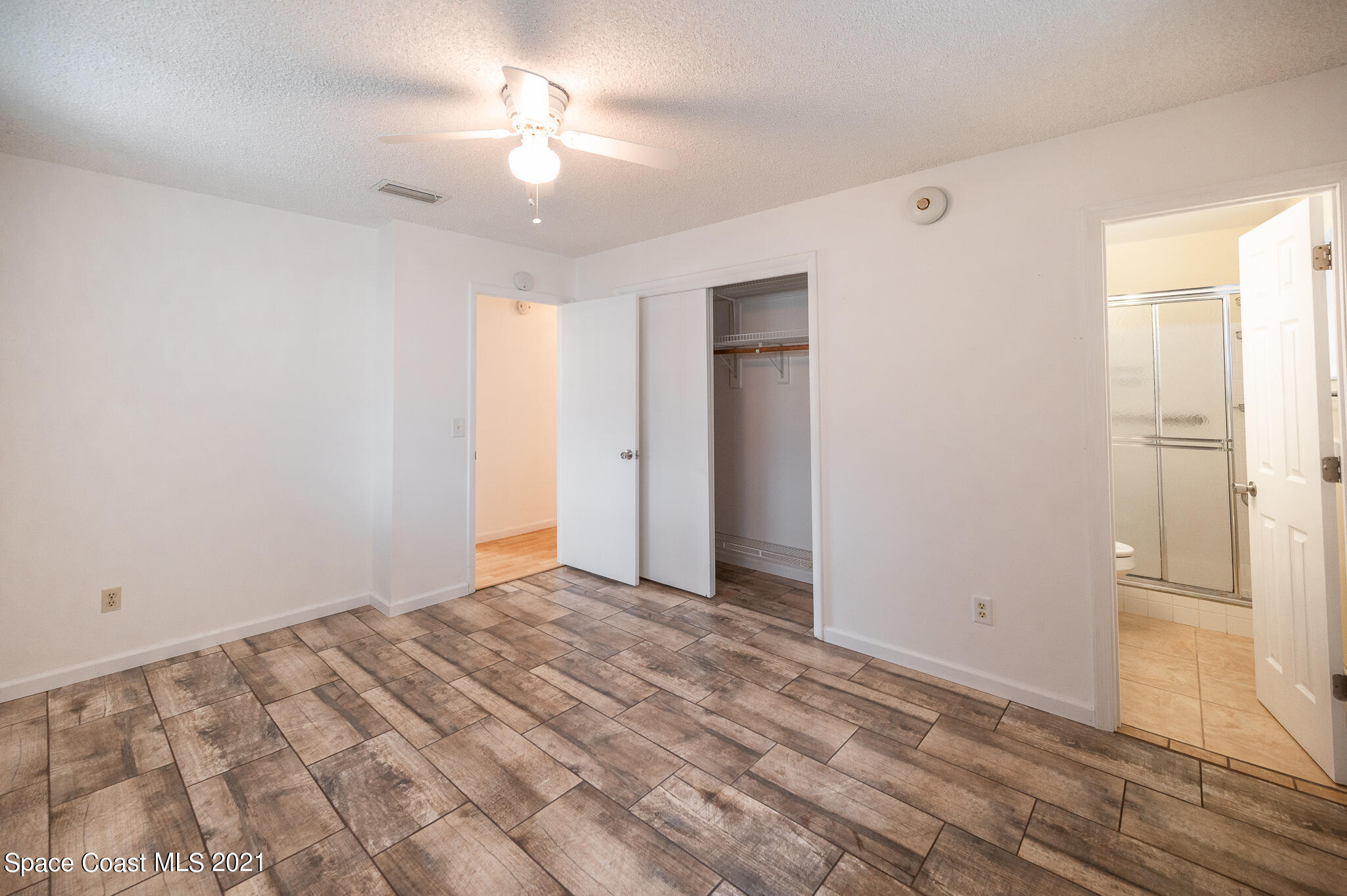 1100 Madrid Road Rockledge, FL 32955 - Photo 22 of 29 a view of empty room with wooden floor and fan