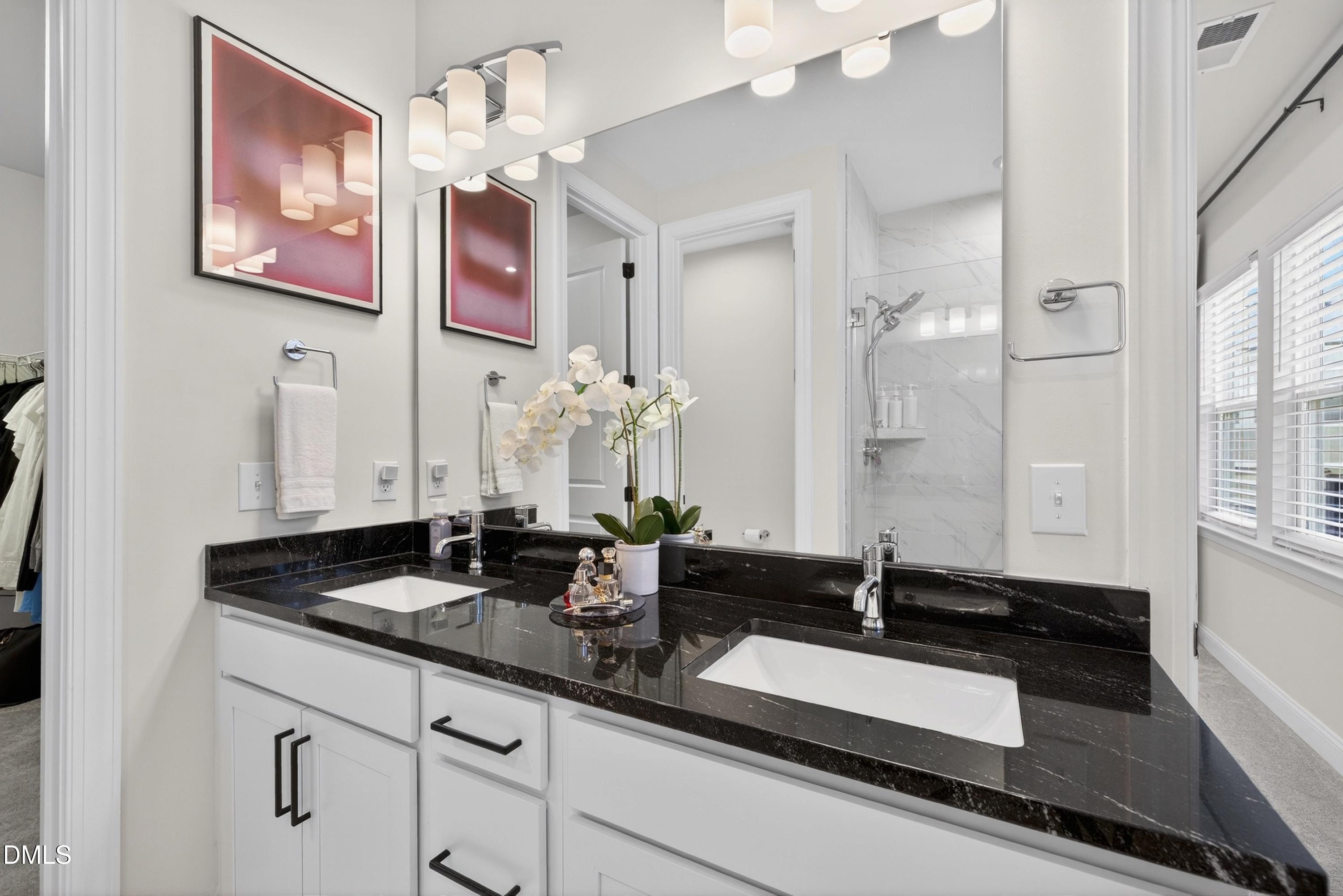 1063 Danvers Loop Apex, NC 27523 - Photo 41 of 67 a bathroom with a granite countertop sink a large mirror and a shower