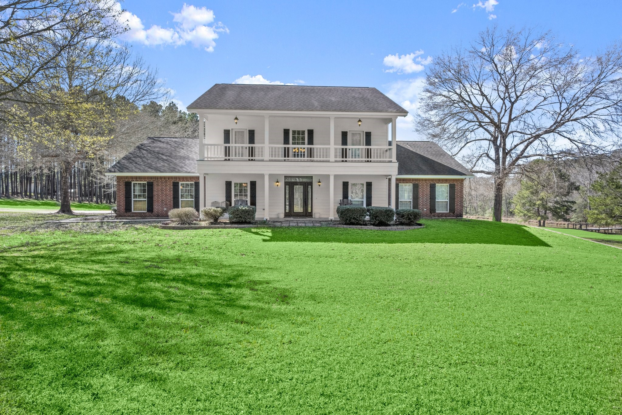 a front view of a house with a garden and trees