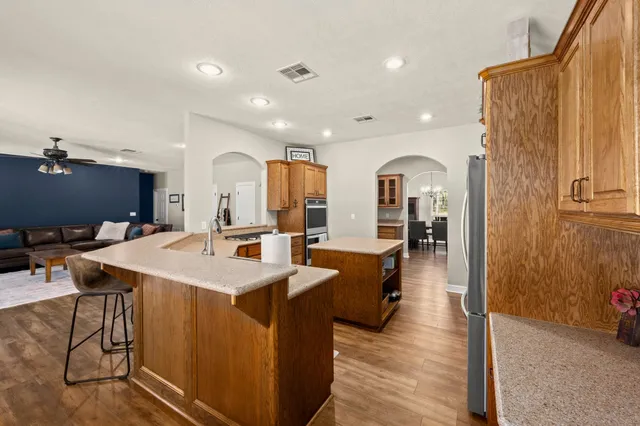 a kitchen with kitchen island granite countertop a sink stove and refrigerator
