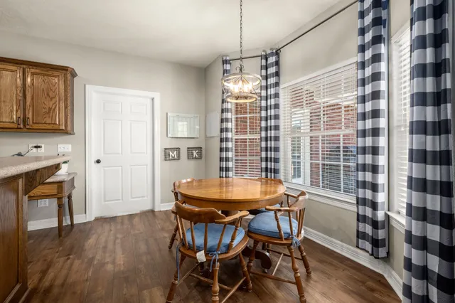a spacious bedroom with a bed a window and potted plant on a dresser