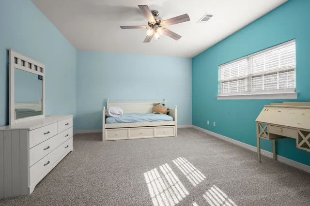 a spacious bedroom with a bed and a chandelier