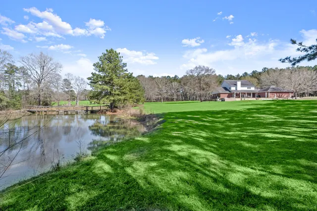 a view of an house with swimming pool and yard