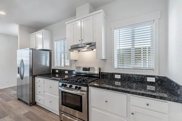 a kitchen with granite countertop a sink and a wooden floor