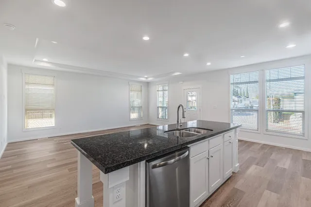 a kitchen with stainless steel appliances granite countertop a sink stove and cabinets