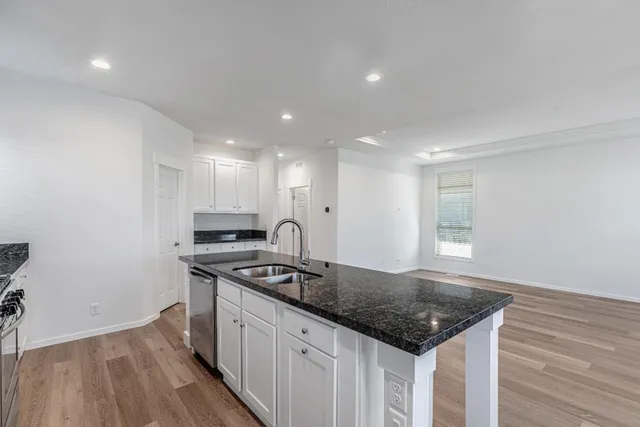 a view of a kitchen with wooden floor and electronic appliances