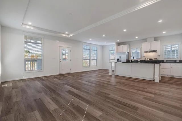 a kitchen with granite countertop a refrigerator and a stove top oven