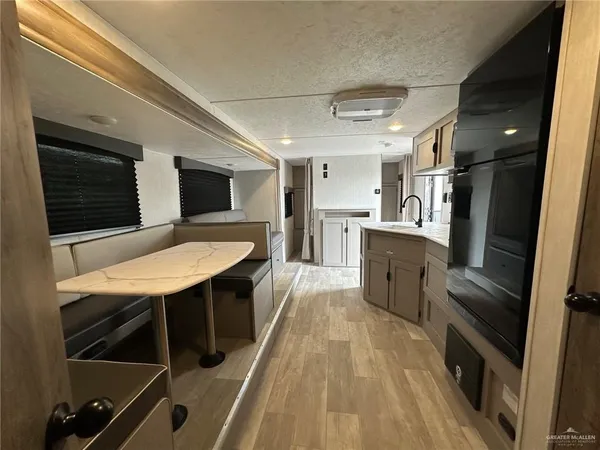 a kitchen with stainless steel appliances a table chairs in it and wooden floors