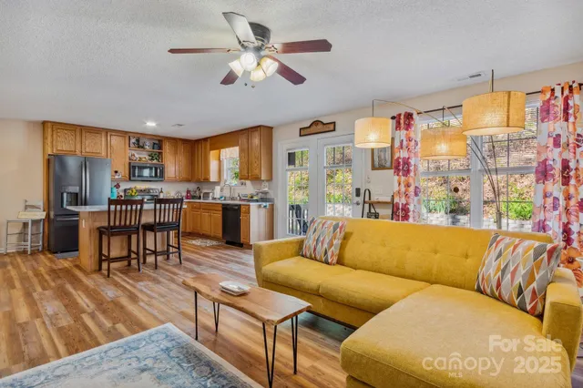 a living room with furniture kitchen and a wooden floor