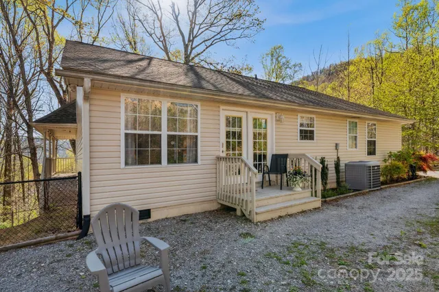 a view of a house with a backyard and chairs