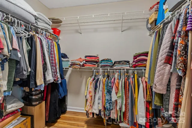 a view of walk in closet with clothes and shoes