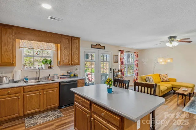a kitchen with stainless steel appliances granite countertop a sink a stove and wooden cabinets