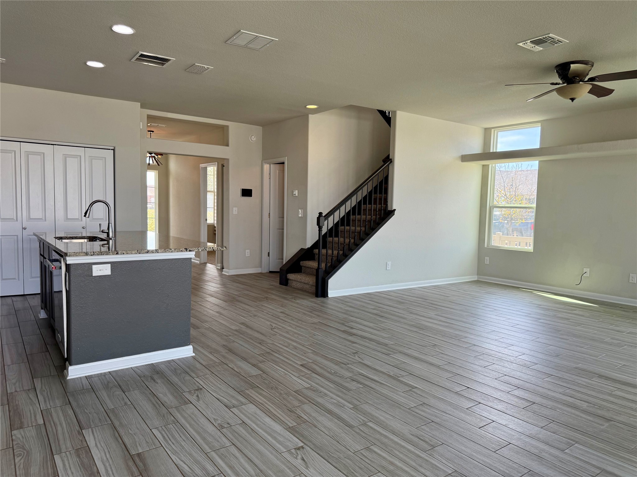 1293 Nevarez Kyle, TX 78640 - Photo 3 of 31 Unfurnished living room featuring stairs, light wood-style floors, visible vents, and ceiling fan
