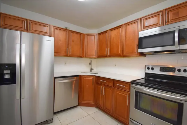 a kitchen with stainless steel appliances granite countertop a refrigerator stove top oven a sink and dishwasher