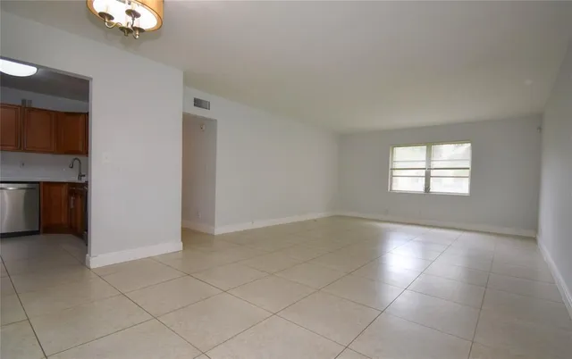an empty room with windows and fireplace