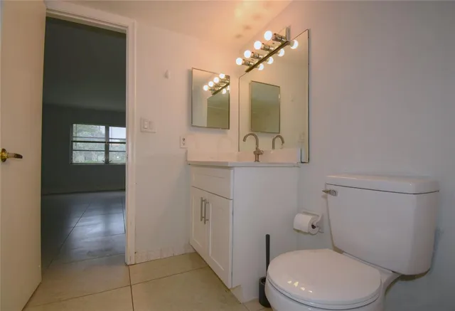 a bathroom with a toilet a sink and mirror