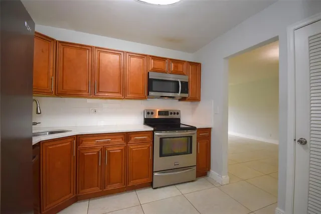 a kitchen with stainless steel appliances granite countertop a stove top oven microwave and cabinets