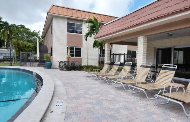 a view of a house with backyard and sitting area