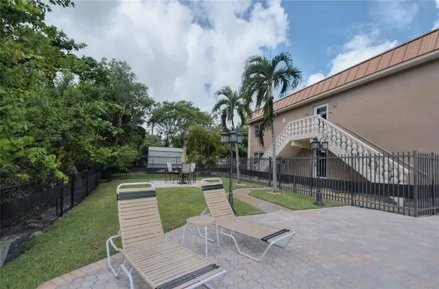 a view of a chair and table in the backyard of the house