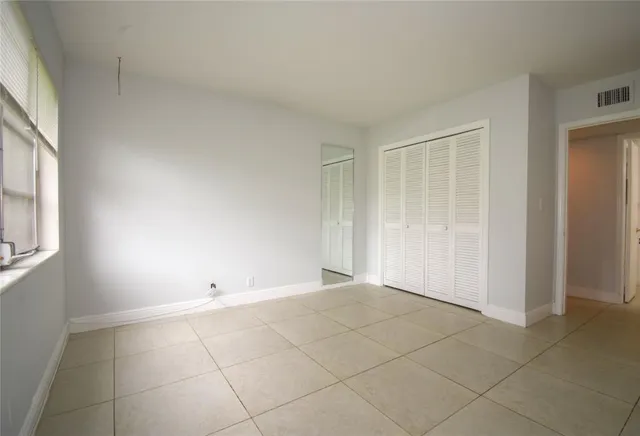 an empty room with white walls and windows