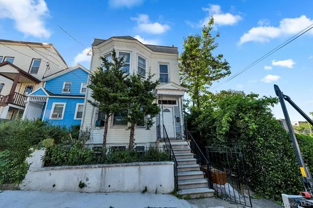a front view of a house with a yard and potted plants