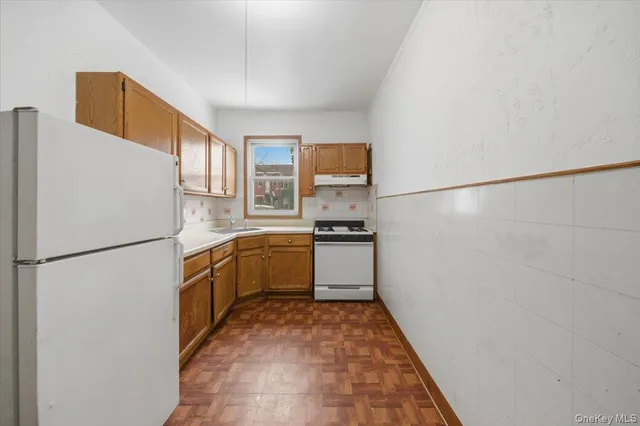 a kitchen with a refrigerator a stove top oven and a counter top space