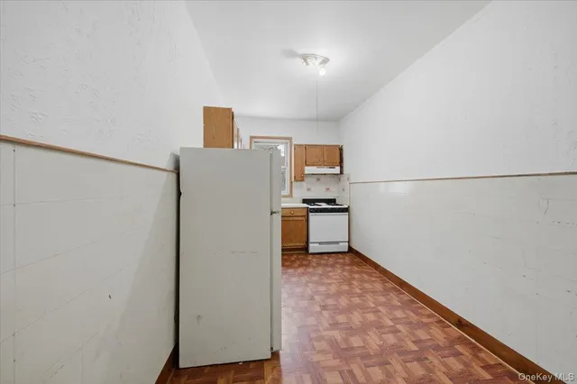 a view of kitchen with refrigerator stove and wooden floor