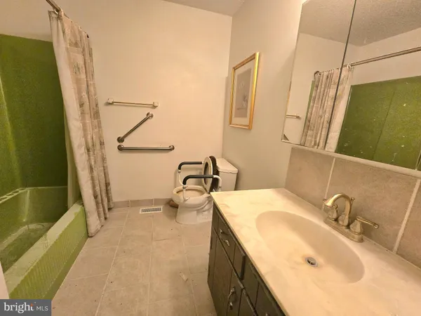 a bathroom with a sink and mirror with bathtub