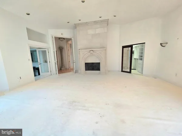 en empty room with windows and fireplace
