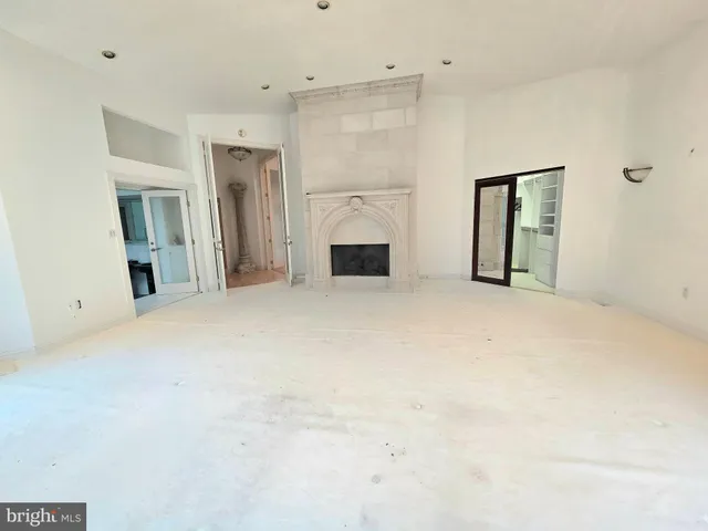 en empty room with windows and fireplace