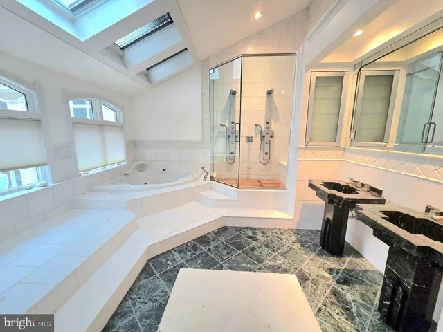 a bathroom with a tub sink and mirror