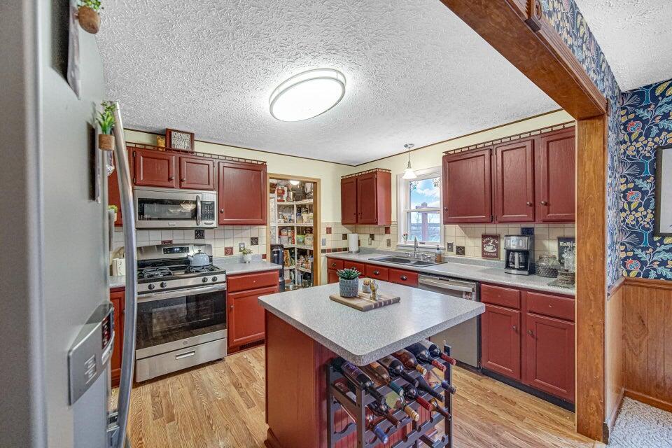 7960 East 173rd Avenue Hebron, IN 46341 - Photo 5 of 36 a kitchen with stainless steel appliances granite countertop a stove top oven a sink dishwasher and cabinets with wooden floor