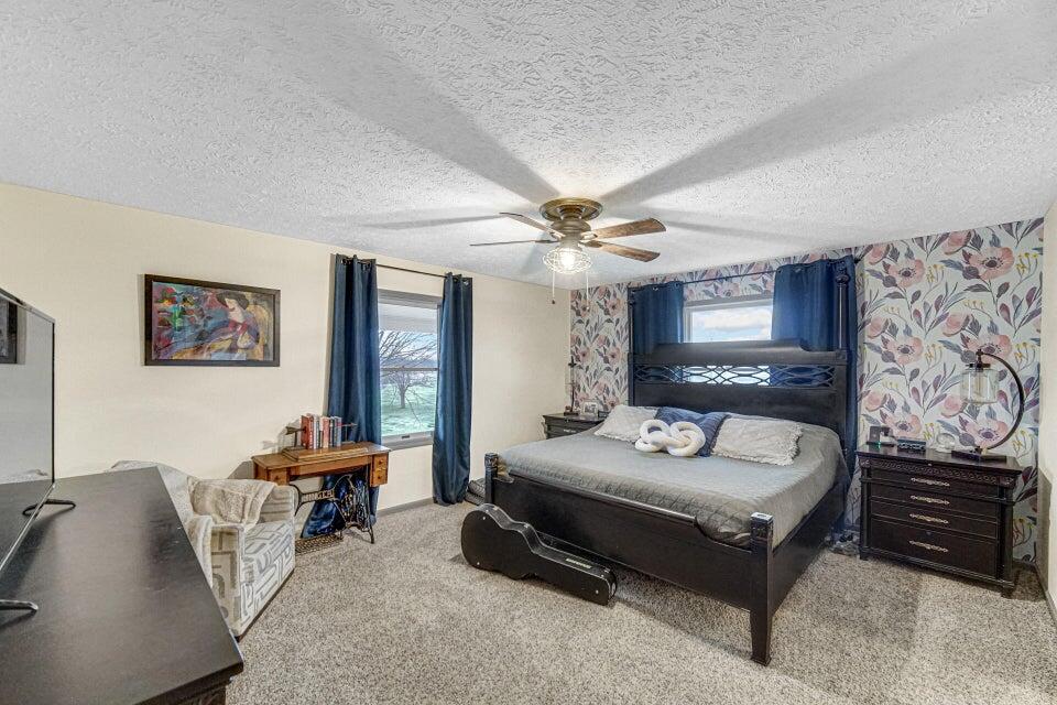 7960 East 173rd Avenue Hebron, IN 46341 - Photo 8 of 36 a spacious bedroom with a bed a desk and chair
