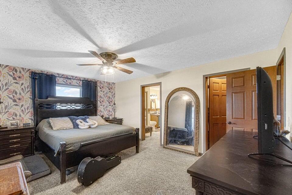 7960 East 173rd Avenue Hebron, IN 46341 - Photo 9 of 36 a bedroom with a bed and a flat screen tv