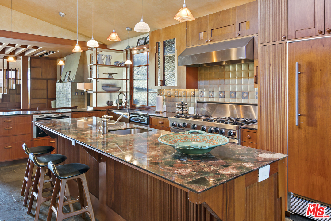 23746 Malibu Road Malibu, CA 90265 - Photo 17 of 46 a kitchen with a table chairs and a stove