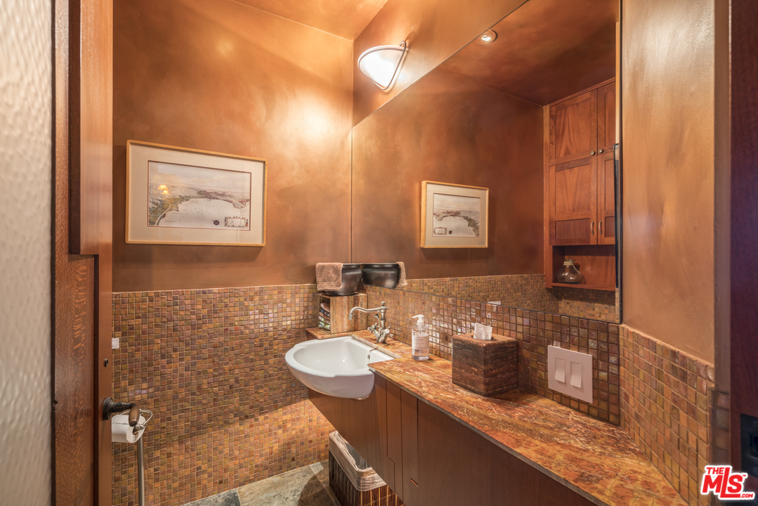 23746 Malibu Road Malibu, CA 90265 - Photo 20 of 46 a bathroom with a granite countertop sink a mirror and a shower
