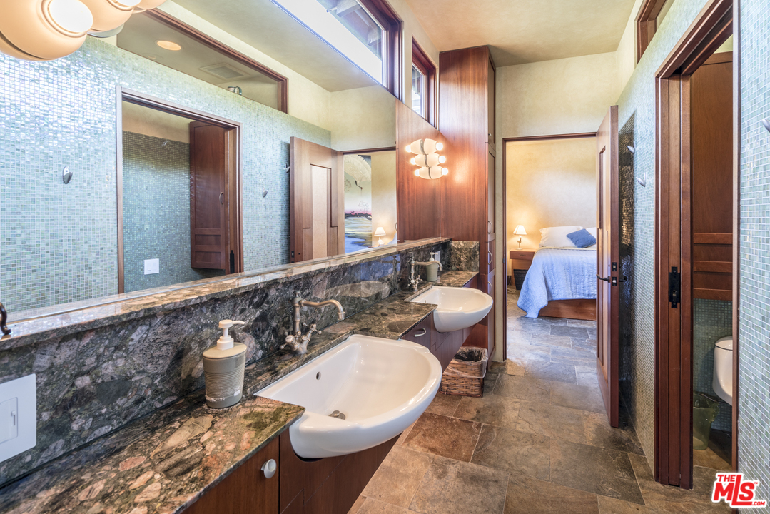 23746 Malibu Road Malibu, CA 90265 - Photo 22 of 46 a bathroom with a tub a sink and a large mirror