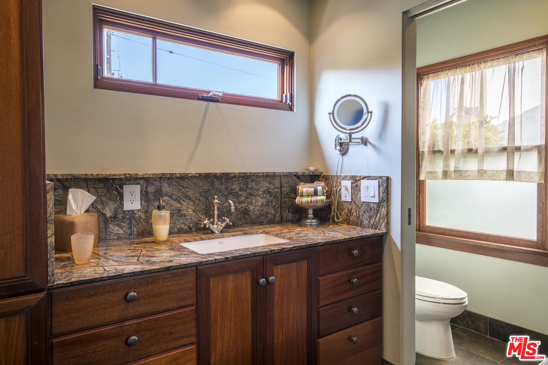 23746 Malibu Road Malibu, CA 90265 - Photo 44 of 46 a bathroom with a granite countertop toilet sink and mirror