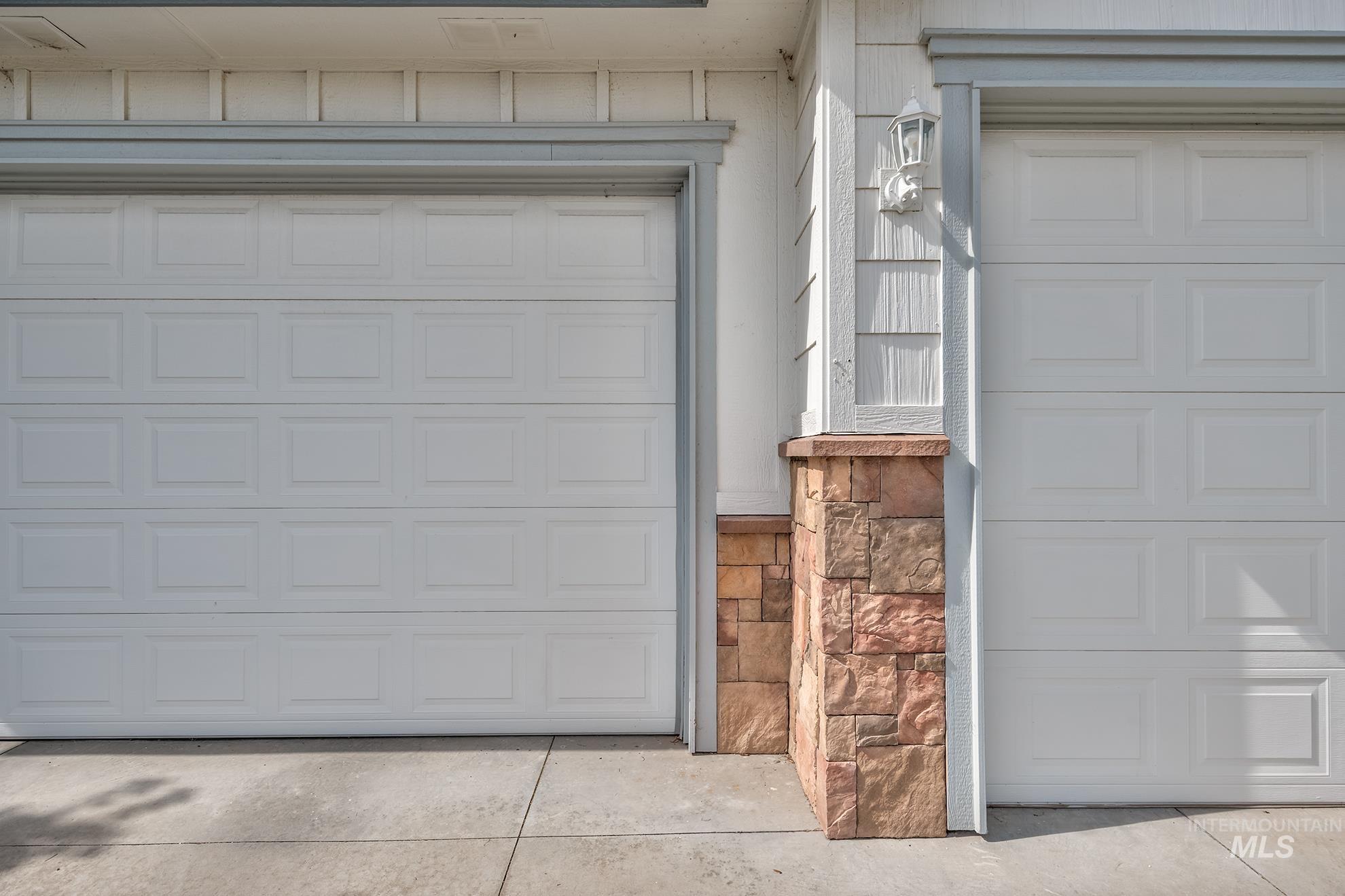 420 West Indianhead Road Weiser, ID 83672 - Photo 40 of 40 Dual panel-style garage doors with stone veneer accents and a concrete driveway