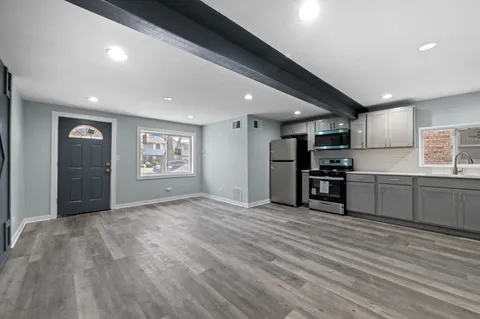 a kitchen with stainless steel appliances granite countertop a refrigerator and a stove top oven