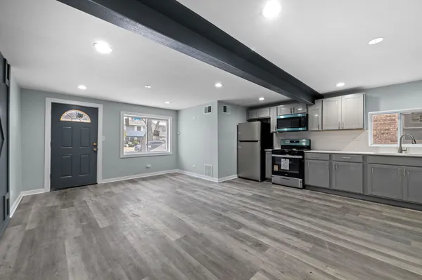 a kitchen with stainless steel appliances granite countertop a refrigerator and a stove top oven