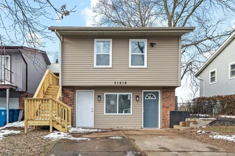 a front view of a house with a tree